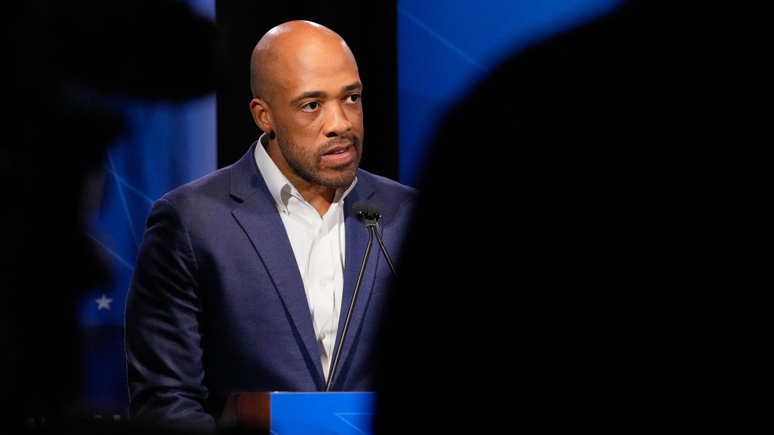 Mandela Barnes speaks into a microphone mounted to the top of a podium, with the shadows of multiple people in the foreground. Mandela Barnes speaks into a microphone mounted to the top of a podium, with the shadows of multiple people in the foreground.