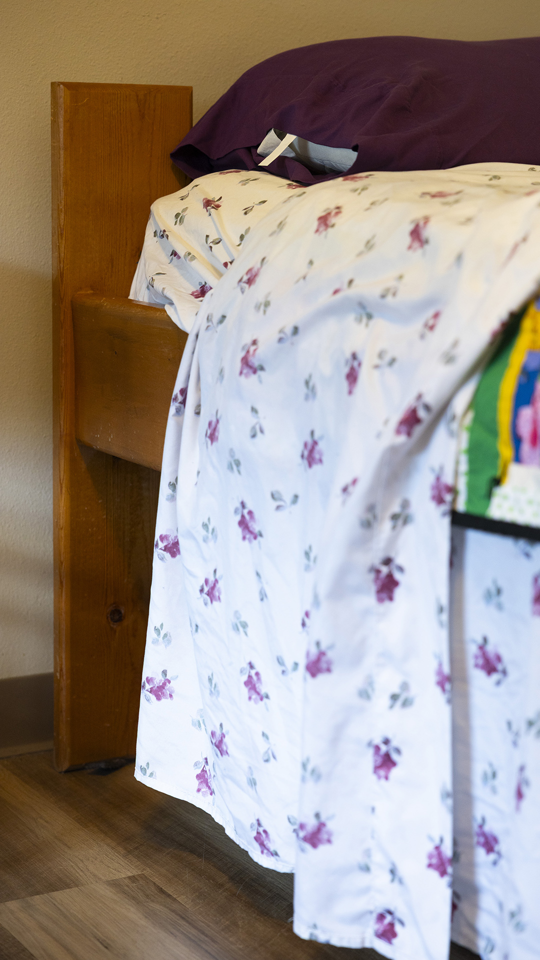 Sheets with a floral pattern cover a bed.