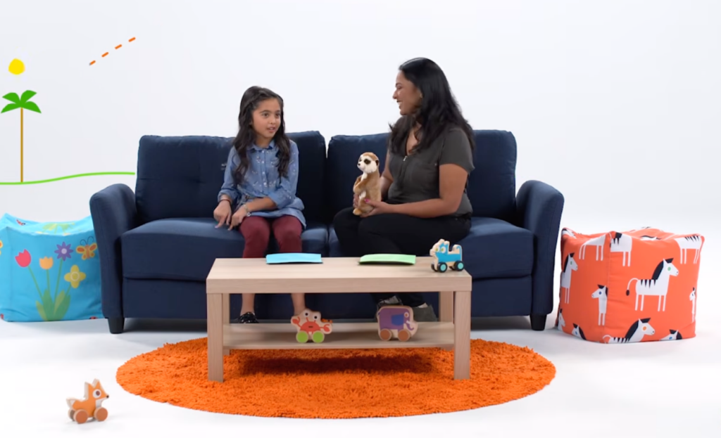 A woman and child sit on a couch talking together.