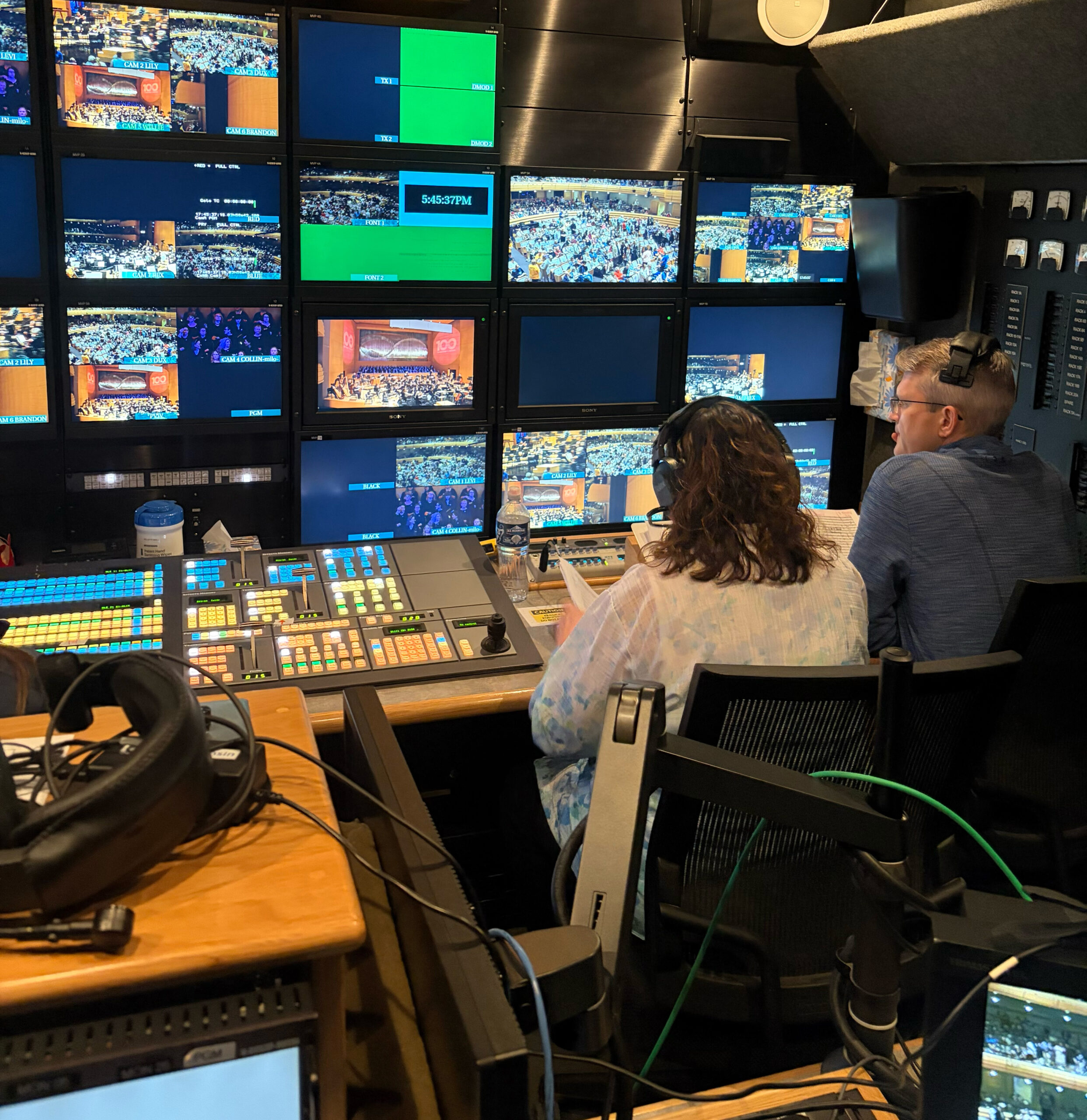PBS Wisconsin co-director Deb Piper (left) works with a score reader in the mobile production unit, monitoring video screens and operating a colorful production switcher during a live event.