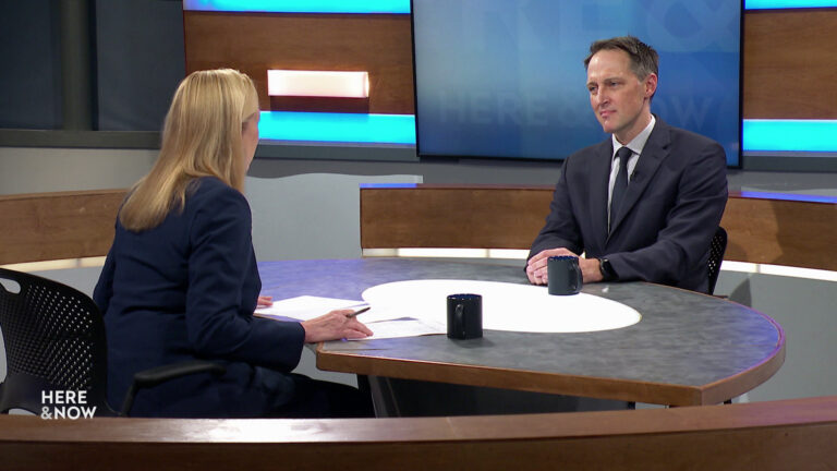 Frederica Freyberg and Ryan Westergaard sit facing each other on the Here & Now set.