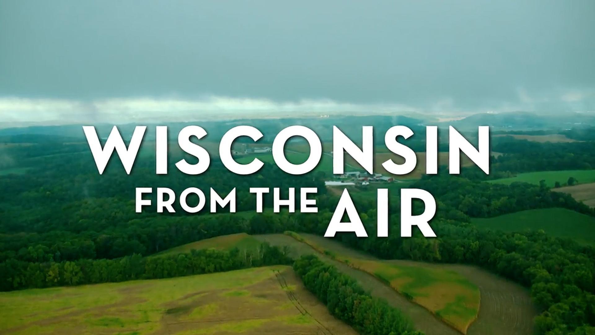 "Wisconsin From the Air" title over an aerial view of wooded hills, farm fields, and a farmstead under gray clouds